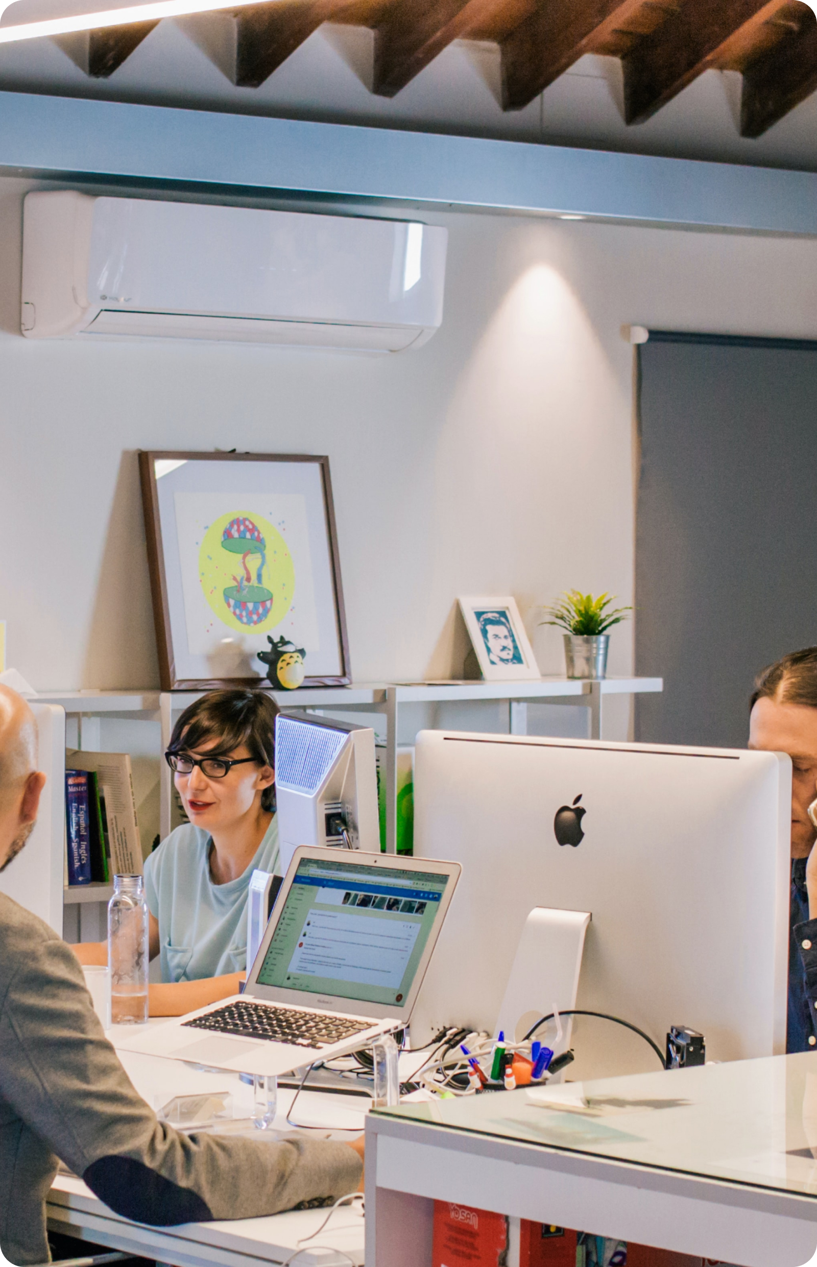 A group of people sitting at a desk with computers