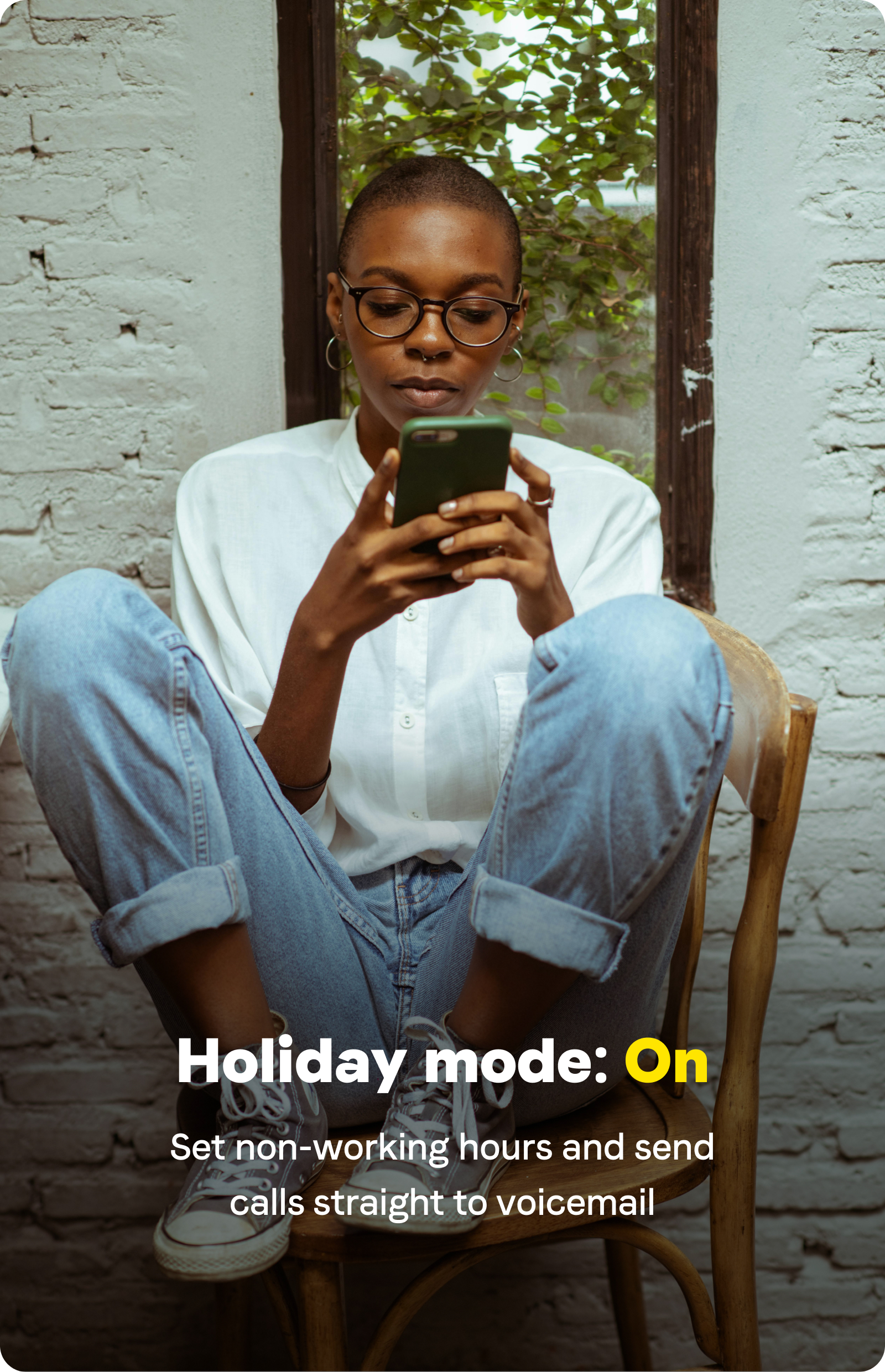 a woman sitting on a chair looking at a phone