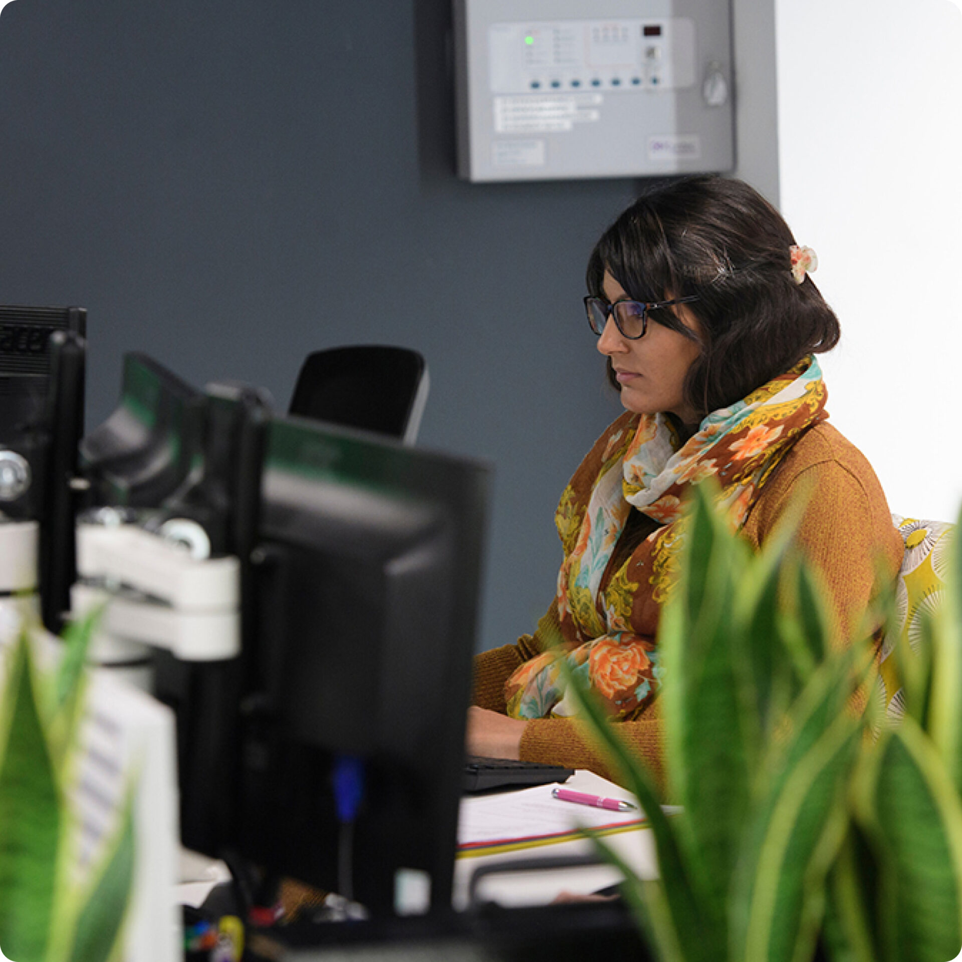 A woman sitting at a desk looking at a computer