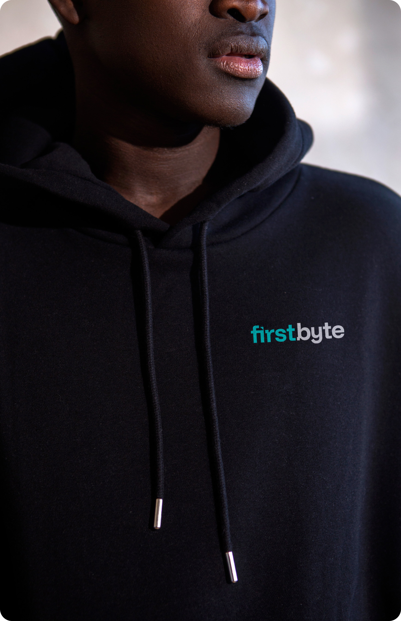 A person wearing a black hoodie with Firstbyte logo on it